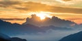 The Alps at sunrise. Colorful sky majestic mountain peaks, fog mist valleys. Sunburst and backlight expansive view from above. Royalty Free Stock Photo