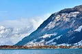 Alps with village houses, snow, forest, blue lake and misty clouds Royalty Free Stock Photo