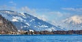 Alps with village houses, snow, forest, blue lake and misty clouds Royalty Free Stock Photo