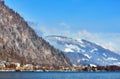 Alps with village houses, snow, forest, blue lake and misty clouds Royalty Free Stock Photo