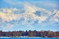 Alps with village houses, snow, forest, blue lake and misty clouds Royalty Free Stock Photo