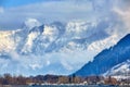 Alps with village houses, snow, forest, blue lake and misty clouds Royalty Free Stock Photo