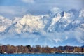 Alps with village houses, snow, forest, blue lake and misty clouds Royalty Free Stock Photo