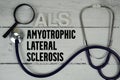 ALS Amyotrophic Lateral Sclerosis text with Stethoscope on wooden background Royalty Free Stock Photo