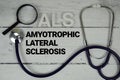ALS Amyotrophic Lateral Sclerosis text with Stethoscope on wooden background Royalty Free Stock Photo