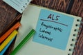 ALS - Amyotrophic Lateral Sclerosis write on sticky notes isolated on Wooden Table Royalty Free Stock Photo