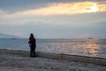 A young couple hugging each other is watching the sea and the city.