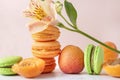 Alstroemeria flowers, peach, green macaroon cookies , fresh apricots on a beige