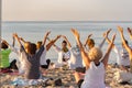 Yoga instructor leading a group session at sunset on the beach in Altafulla, Tarragona, Spain