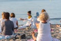 Yoga instructor leading a group session at sunset on the beach in Altafulla, Tarragona, Spain