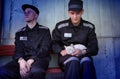 Prisoners play with a cat in the prison yard