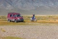 Altai, Mongolia - June 14, 2017: Car and motorbike on road in the desert mountain of the Mongolia