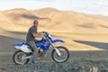 Altai, Mongolia - June 14, 2017: A happy motorcyclist is preparing a trip