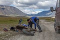Altai, Mongolia - June 14, 2017: Male tourist is repairing a motorcycle. The nature of Mongolia