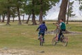 Altai, Mongolia - June 14, 2019: A Mongolian boys is cycling, looking at the photographer and laughing