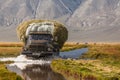 Altai, Mongolia - June 14, 2017: Truck on a road covered with water after a flood. Altai, Mongolia