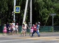 Children cross the road at a pedestrian crossing in the village of Mayma of the Altai Republic Royalty Free Stock Photo