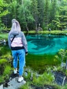 Altai Republic, Siberia, Russia - June 2020. A girl next to a blue geyser lake in the Altai mountains. Royalty Free Stock Photo