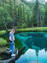 Altai Republic, Siberia, Russia - June 2020. A girl next to a blue geyser lake in the Altai mountains. Royalty Free Stock Photo