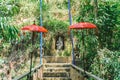 The altar of the Hindu God Ganesha in the jungle. Red traditional umbrellas and blue flags adorn the altar