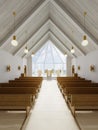 Altar and interior of the catalytic church with wooden benches and a large atrium window Royalty Free Stock Photo