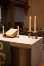 Altar in an old church with a bible and candlelight on it Royalty Free Stock Photo