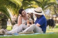 Alternative animal love family couple play with young puppy shetland collie on the meadow in a park - playful people with dogs Royalty Free Stock Photo