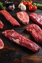 Alternative beef cut machete skirt steak close up in front of other cuts in butchery on old wood table side view selective focus Royalty Free Stock Photo