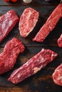 Alternative beef cut machete skirt steak close up in front of other cuts in butchery on old wood table top view vertical Royalty Free Stock Photo