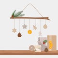 Alternative Christmas tree made with branch and wood, paper, textile toys, pine cone, dry orange hanging on a rope. Shelf with