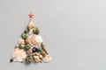 Alternative Christmas tree made from seashells and with a red starfish on a light gray background. Royalty Free Stock Photo