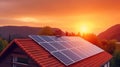 Alternative electricity source. Solar panels, photovoltaics on the red roof of a house and a beautiful sky with the setting sun.