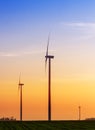 Alternative energy concept, windmills at sunset Royalty Free Stock Photo