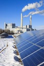 Alternative energy - rack of brand new solar panels. Thermal power plant in the background. Royalty Free Stock Photo