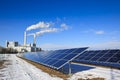 Alternative energy - rack of brand new solar panels. Thermal power plant in the background. Royalty Free Stock Photo