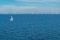 Alternative energy - row of offshore wind turbines and yacht at sea, green energy windmill generators at sea Royalty Free Stock Photo