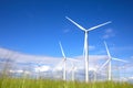 Alternative energy source. Wind turbines in field under sky, low angle view Royalty Free Stock Photo