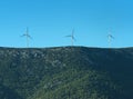 Alternative energy sources concept. Giant white windmills on mountains. Windmills, wind generators on hill, mountain Royalty Free Stock Photo