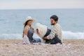 Alternative family with one lady a man and a dog together at the beach enjoying a picnic in friendship and partenership Royalty Free Stock Photo