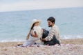 Alternative family with one lady a man and a dog together at the beach enjoying a picnic in friendship and partenership Royalty Free Stock Photo