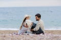 Alternative family with one lady a man and a dog together at the beach enjoying a picnic in friendship and partenership Royalty Free Stock Photo