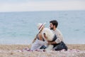 Alternative family with one lady a man and a dog together at the beach enjoying a picnic in friendship and partenership Royalty Free Stock Photo