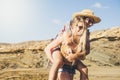 Alternative funny couple have fun together at the beach in sunny day of vacation - girl carry young men on his back and both laugh Royalty Free Stock Photo