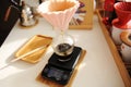 Alternative manual coffee brewing. Pink ceramic origami dripper on electronic scale