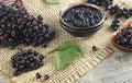 Fresh ripe black elderberries, elderberry syrup and leaves of elderberry on rustic wooden boards background Royalty Free Stock Photo