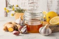 Alternative medicine, natural home remedy for cold and flu. Glass jar with honey, ginger, lemon, garlic and camomile Royalty Free Stock Photo