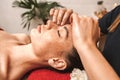 Alternative Medicine. Therapist healing lying woman peaceful close-up doing face massage