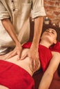 Alternative Medicine. Therapist healing woman closed eyes relaxed doing ayurvedic massage on belly