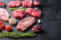 Alternative raw beef steak cuts with top blade, chuck roll and rump steak, with herbs and pomegranate side view, space for text Royalty Free Stock Photo