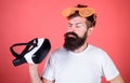 Alternative reality. Man bearded hipster with virtual reality headset and louvered sunglasses red background. Which